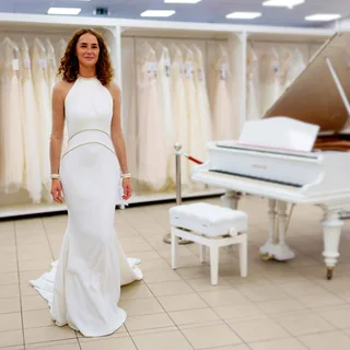 Model im Brautkleid neben dem weißen Flügel bei Herzlich Braut