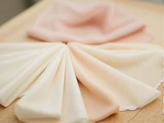 Wedding dress fabrics in ivory, blush, and warm champagne tones